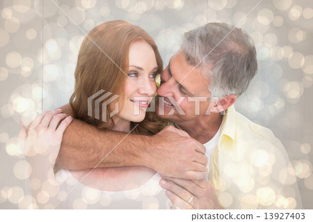Composite image of casual couple smiling and hugging Composite image of casual couple smiling and hugging 13927403