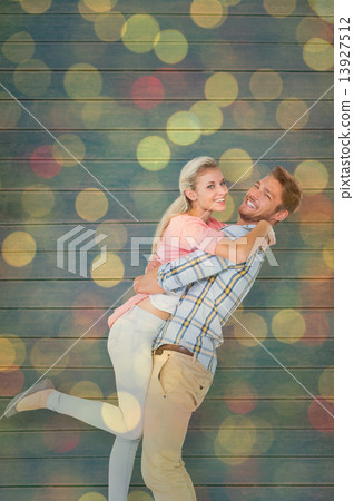 Composite image of handsome man picking up and hugging his girlf Composite image of handsome man picking up and hugging his girlf 13927512