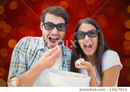 Composite image of attractive young couple watching a 3d movie Composite image of attractive young couple watching a 3d movie 13927613
