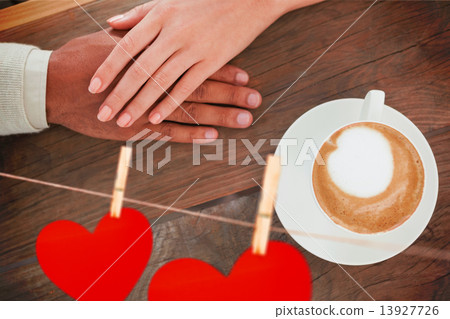 Composite image of couple holding hands beside cappuccino Composite image of couple holding hands beside cappuccino 13927726
