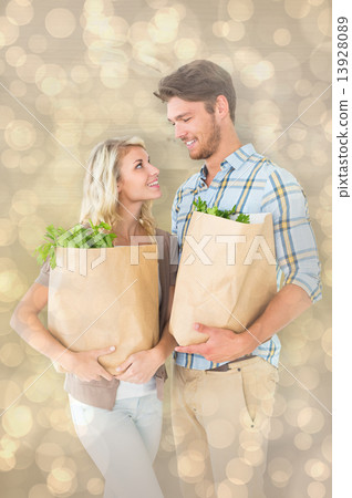 Composite image of attractive couple holding their grocery bags Composite image of attractive couple holding their grocery bags 13928089