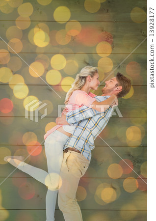 Composite image of handsome man picking up and hugging his girlf Composite image of handsome man picking up and hugging his girlf 13928177