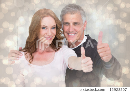 Composite image of casual couple showing thumbs up Composite image of casual couple showing thumbs up 13928207