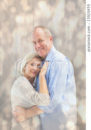 Composite image of happy mature couple hugging and smiling 13928459