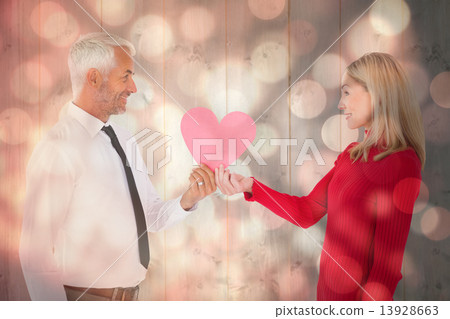 Composite image of handsome man getting a heart card form wife 13928663