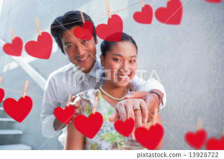 Composite image of couple showing engagement ring on womans fing 13928722