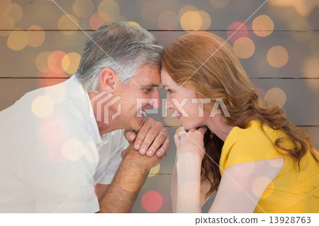 Composite image of casual couple smiling at each other Composite image of casual couple smiling at each other 13928763