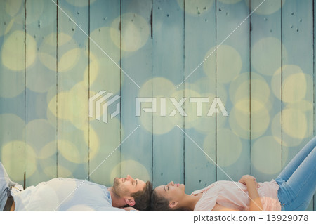 Composite image of attractive young couple lying down 13929078