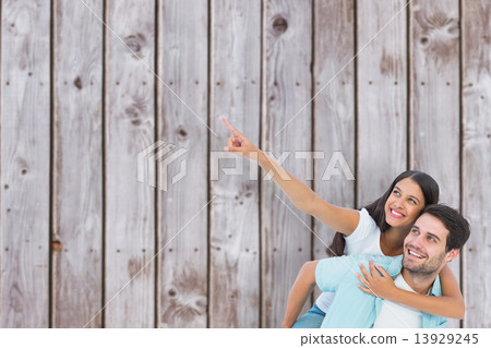 Composite image of happy casual man giving pretty girlfriend pig Composite image of happy casual man giving pretty girlfriend pig 13929245