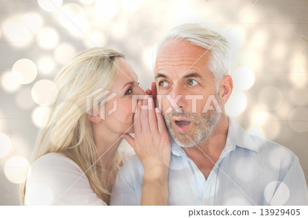 Composite image of woman whispering a secret to husband 13929405