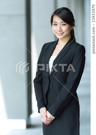 One young successful Chinese businesswoman along office building walkway One young successful Chinese businesswoman along office building walkway 13933970