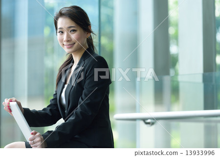 One young successful Chinese businesswoman using tablet iPad 13933996