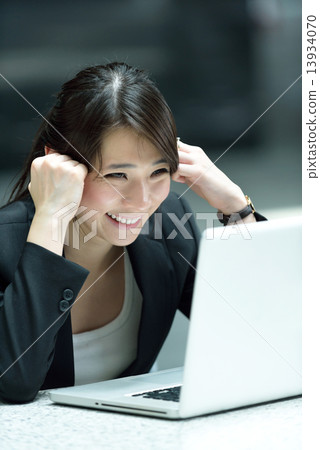 One young successful Chinese businesswoman using laptop along promenade 13934070