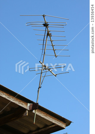 Old TV antenna on house roof with bule sky Old TV antenna on house roof with bule sky 13936454