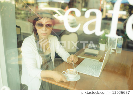 Asian woman drinking coffee in cafe. 13936687
