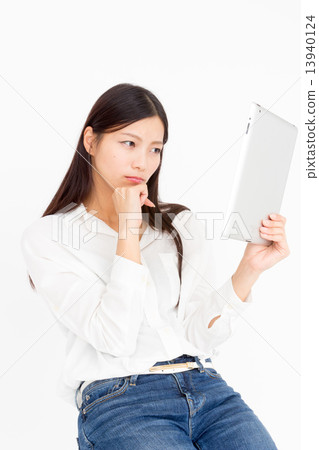 A woman looking for information on a tablet A woman looking for information on a tablet 13940124