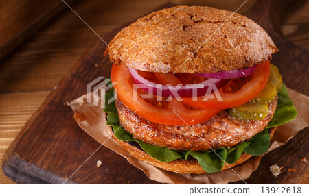 Burger close up on a cutting board on wooden background. 13942618
