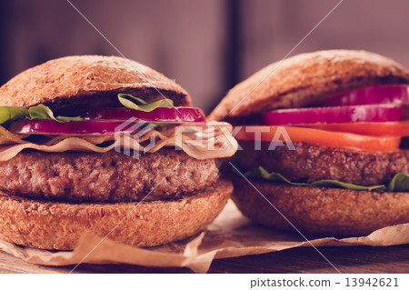 Two burgers close up on a cutting board. Vintage style. Two burgers close up on a cutting board. Vintage style. 13942621
