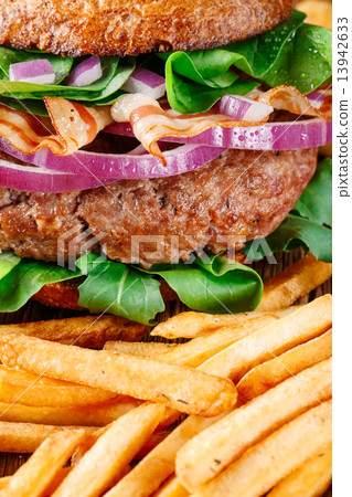 Burger and french fries close up on wooden background. 13942633