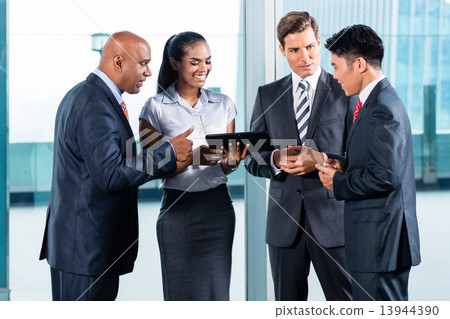 Business team discussing in front of skyline 13944390