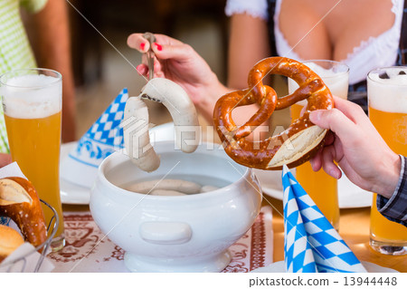 People eating veal sausage in bavarian restaurant 13944448