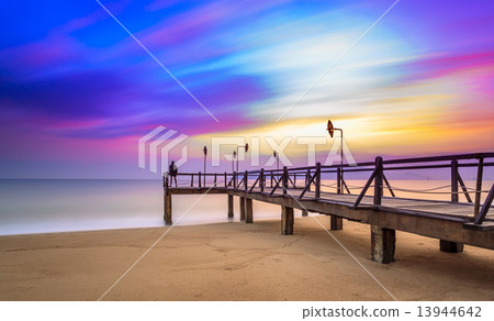 Long exposure of colorful sunrise and wooden pier Long exposure of colorful sunrise and wooden pier 13944642