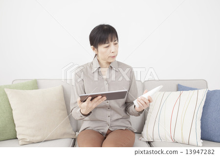 拿著片劑和化妝用品的中間婦女 13947282