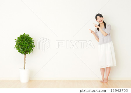 A woman pointing at a room A woman pointing at a room 13948703
