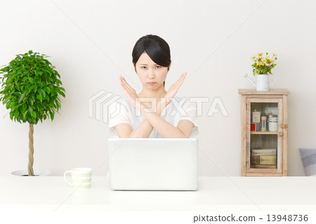 A woman crosses in front of a personal computer 13948736