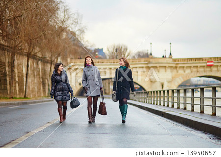 Three cheerful girls walking together in Paris 13950657