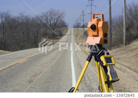 Theodolite set on the edge of road 13972645