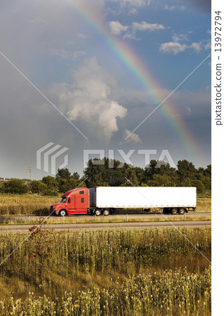 Semi truck driving under the rainbow 13972794