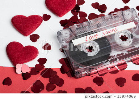 Audio cassette tape on red backgound with fabric heart 13974069