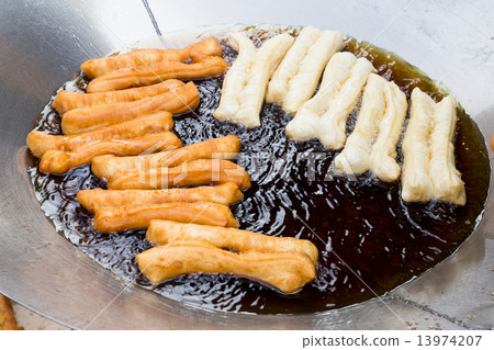 Deep frying bread stick or popularly known as You Tiao, a popular Chinese delicacy. Deep frying bread stick or popularly known as You Tiao, a popular Chinese delicacy. 13974207