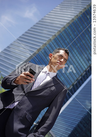 Confident looking Caucasian Man holding his smart phone Confident looking Caucasian Man holding his smart phone 13974639