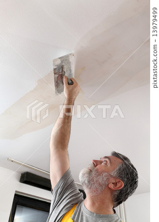 Worker repairing plaster at ceiling Worker repairing plaster at ceiling 13979499