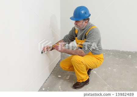Electrician at construction site testing installation Electrician at construction site testing installation 13982489