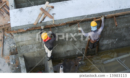 Construction Workers dismantling formwork Construction Workers dismantling formwork 13983113