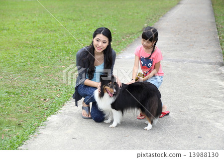 Mother daughter and pet dog at park  13988130