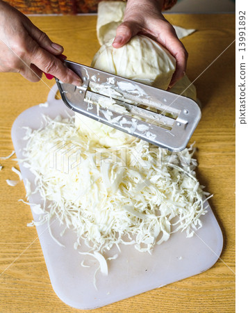 woman chopping cabbage on cutting board 13991892
