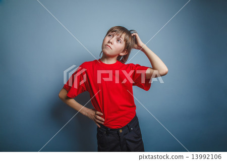 European-looking boy of ten years thinking, scratching his head  13992106