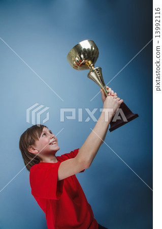 a boy of twelve European appearance holds the cup, the reward, t 13992116