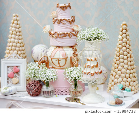 Elegant sweet table with big cake and macaroon on dinner or event party  13994738
