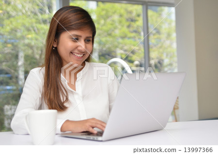Young indian businesswoman on a coffee break. Using tablet compu 13997366