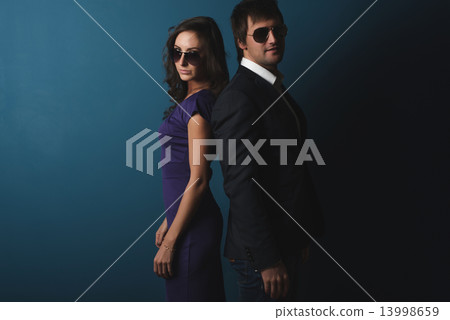 Perfect spy couple man and woman in glasses standing posing. Perfect spy couple man and woman in glasses standing posing. 13998659