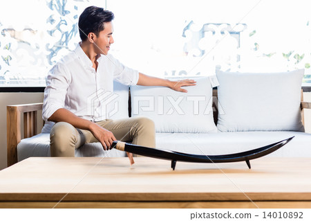 Asian man on sofa couch in furniture store Asian man on sofa couch in furniture store 14010892