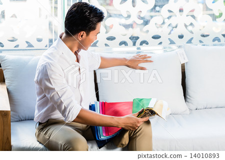 Asian man on sofa couch in furniture store Asian man on sofa couch in furniture store 14010893