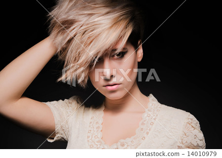 Blonde girl with a short stylish haircut on a dark background  14010979