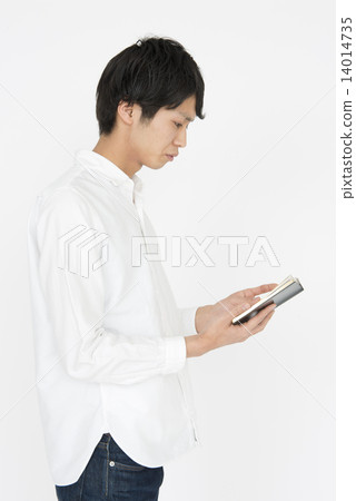 A person reading a notebook with a serious look A person reading a notebook with a serious look 14014735