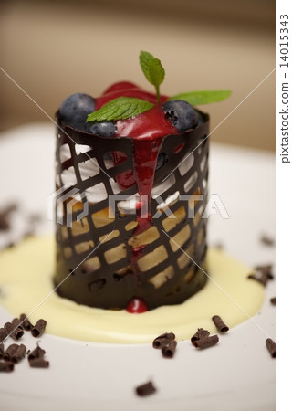 Cylindrical cheesecake in chocolate basket with blueberries 14015343